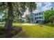 Beautiful two-story blue house with double porches, green lawn and mature trees surrounding the home at 3711 Tip Ln, Mount Pleasant, SC 29466