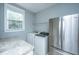 Spacious laundry room features a Whirlpool washer and dryer, stainless steel refrigerator, and granite countertops at 3711 Tip Ln, Mount Pleasant, SC 29466