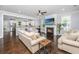 Cozy living room featuring hardwood floors, fireplace, ceiling fan, and view into kitchen at 3711 Tip Ln, Mount Pleasant, SC 29466