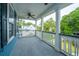 Outdoor porch area with white columns and railings, ceiling fan, and views of mature trees at 3711 Tip Ln, Mount Pleasant, SC 29466