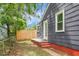 A fenced backyard with a partial view of the side and rear of a gray house at 3935 Walnut St, North Charleston, SC 29405