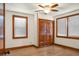 Bedroom featuring hardwood floors, two windows with wooden trim, a ceiling fan, and closet at 3935 Walnut St, North Charleston, SC 29405