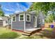 A charming gray home, surrounded by green grass, featuring an inviting backyard space and wood fence at 3935 Walnut St, North Charleston, SC 29405