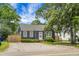 View of a home exterior featuring landscaping and a gravel driveway on a sunny day at 3935 Walnut St, North Charleston, SC 29405