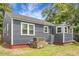 View of the home's exterior featuring grey siding, well-maintained lawn, and updated HVAC system at 3935 Walnut St, North Charleston, SC 29405
