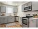 Bright kitchen features stainless appliances, stylish backsplash, and wood-look flooring at 3935 Walnut St, North Charleston, SC 29405