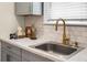 Close up of stainless steel sink, gold faucet, and marble countertops at 3935 Walnut St, North Charleston, SC 29405