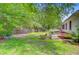 A spacious backyard offers a patio and ample green space, surrounded by mature trees at 4 Garth Dr, Charleston, SC 29414