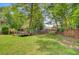 Large grassy backyard with mature trees and wooden fence, perfect for outdoor activities at 4 Garth Dr, Charleston, SC 29414