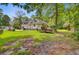 Expansive backyard with lush grass, tall trees, a shed, and a charming home exterior at 4 Garth Dr, Charleston, SC 29414