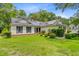 A charming single-story home adorned with solar panels, nestled among mature trees and a well-kept lawn at 4 Garth Dr, Charleston, SC 29414