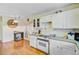 This kitchen features laminate countertops, white cabinetry and appliances, and hardwood floors at 4 Garth Dr, Charleston, SC 29414