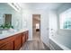 Bright bathroom with double vanity, soaking tub, and wood-look floors provides a comfortable retreat at 414 Dovetail Cir, Summerville, SC 29483