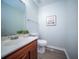 Bathroom featuring a cherry vanity with white sink, a toilet, and a framed art piece at 414 Dovetail Cir, Summerville, SC 29483