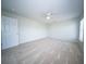 Bright bedroom with neutral carpet, ceiling fan, and an open white door at 414 Dovetail Cir, Summerville, SC 29483