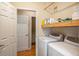 Well-lit laundry room with washer, dryer, shelving, and access to another room at 417 Dennis Ave, Moncks Corner, SC 29461