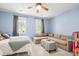 Inviting bedroom featuring a cozy sectional sofa, soft blue walls, and ample natural light at 5032 Coral Reef Dr, Johns Island, SC 29455