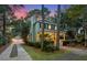 Charming two-story home with manicured landscaping, a detached garage and a brick walkway at dusk at 5032 Coral Reef Dr, Johns Island, SC 29455