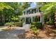 Charming two-story home featuring a welcoming front porch, verdant landscaping, and an American flag at 5032 Coral Reef Dr, Johns Island, SC 29455