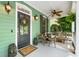 Inviting porch with ferns, comfortable seating, a ceiling fan and decorative wall lighting at 5032 Coral Reef Dr, Johns Island, SC 29455