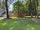 Expansive backyard with a well-maintained lawn, mature trees, and a privacy fence at 5445 Ansley Trl, North Charleston, SC 29418