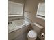 Modern bath with soaking tub, tiled walls and two windows at 5445 Ansley Trl, North Charleston, SC 29418