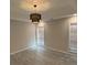 Light-filled bedroom with a modern chandelier, tray ceiling, and two large windows at 5445 Ansley Trl, North Charleston, SC 29418