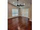 Light-filled bedroom with hardwood floors, a large ceiling fan, and two large windows at 5445 Ansley Trl, North Charleston, SC 29418