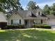 Charming home with a green lawn, dormer windows, green shutters, and a two-car garage at 5445 Ansley Trl, North Charleston, SC 29418