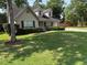 Charming home featuring a well-manicured lawn, mature trees, and a welcoming front porch at 5445 Ansley Trl, North Charleston, SC 29418