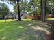 Landscaped home exterior with a lush green lawn and a charming, light-colored facade, complemented by mature trees at 5445 Ansley Trl, North Charleston, SC 29418