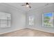 Well-lit bedroom with hardwood floors, ceiling fan, and white trim windows at 578 Mountain Laurel Cir, Goose Creek, SC 29445