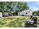 Spacious backyard with green grass, shade trees, patio and additional seating areas at 5806 Robinhood Dr, Hanahan, SC 29410