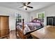 Bedroom featuring hardwood floors, a ceiling fan, and natural light from dual windows creating a comfortable space at 5806 Robinhood Dr, Hanahan, SC 29410