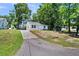 View of the home featuring a long driveway and manicured front lawn at 5806 Robinhood Dr, Hanahan, SC 29410