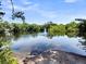 Scenic view of a calm lake with a fountain, reflecting the sky and surrounding trees at 5806 Robinhood Dr, Hanahan, SC 29410