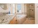 Well-lit bathroom with granite counters, a soaking tub and a separate glass shower at 601 Ocean Blvd, Isle of Palms, SC 29451