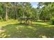 Spacious backyard featuring a rustic pergola surrounded by lush greenery and tall trees at 617 Willdrew Ln, Moncks Corner, SC 29461