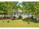 A lush, green lawn surrounds this cozy home, complemented by mature trees, a classic porch, and vibrant landscaping at 617 Willdrew Ln, Moncks Corner, SC 29461