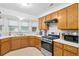 Well-lit kitchen featuring oak cabinets, stainless steel appliances, and ample counter space for meal preparation and cooking at 617 Willdrew Ln, Moncks Corner, SC 29461
