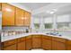 Traditional kitchen with wooden cabinets, white countertops, and a double basin sink beneath bright windows at 617 Willdrew Ln, Moncks Corner, SC 29461