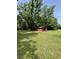 Exterior view of a backyard shed with a large green lawn and shade trees at 6287 Sniders Hwy, Walterboro, SC 29488