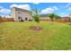 Lush backyard with healthy green grass, young trees and a view of neighboring homes at 716 Mcroy St, Moncks Corner, SC 29461