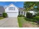 Charming white home with a well-manicured lawn, attached garage, and lovely landscaping at 7302 Sanderling Ct, Hanahan, SC 29410
