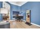 Stylish living room featuring a grand piano, blue accent wall, and view into adjoining dining area at 7302 Sanderling Ct, Hanahan, SC 29410