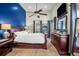 Main bedroom with en-suite, dark wood furnishings, ceiling fan, and a bright blue accent wall at 7302 Sanderling Ct, Hanahan, SC 29410