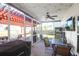 Covered outdoor screened in porch with dark table and grill with a fan and lights at 7302 Sanderling Ct, Hanahan, SC 29410