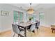 Bright dining room featuring a wooden table, wicker chandelier, and access to the backyard through French doors at 734 Fort Sumter Dr, Charleston, SC 29412
