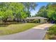 Spacious home with a long driveway, lush lawn, and mature trees, offering privacy and curb appeal at 734 Fort Sumter Dr, Charleston, SC 29412