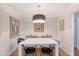 Dining room featuring a pendant light, white table, black chairs, and decorative pillows on a bench at 803 Burnett Dr, Charleston, SC 29412